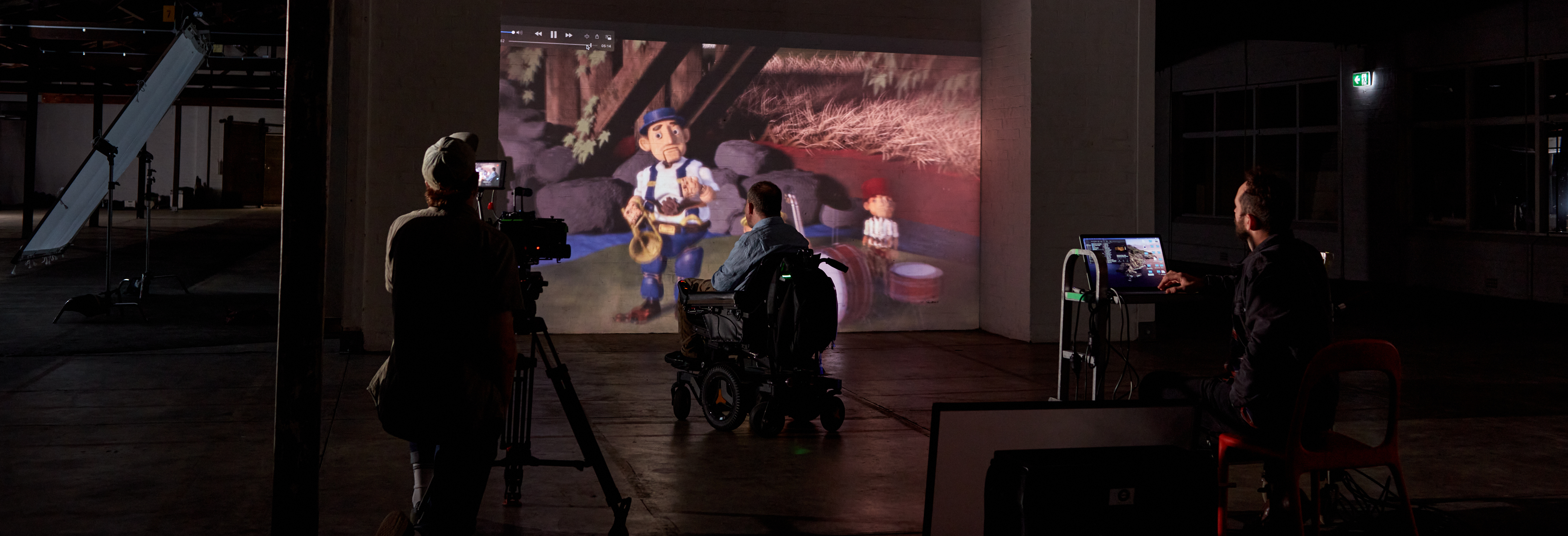 A wheelchair user watching a movie in a dark cinema and being filmed